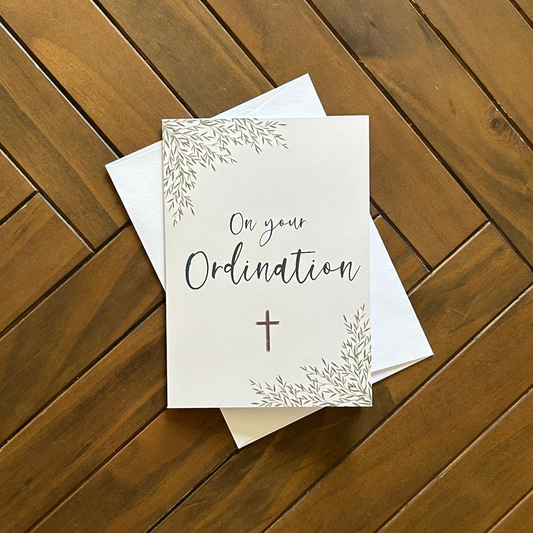 Card with 'On your Ordination' text on a wooden surface