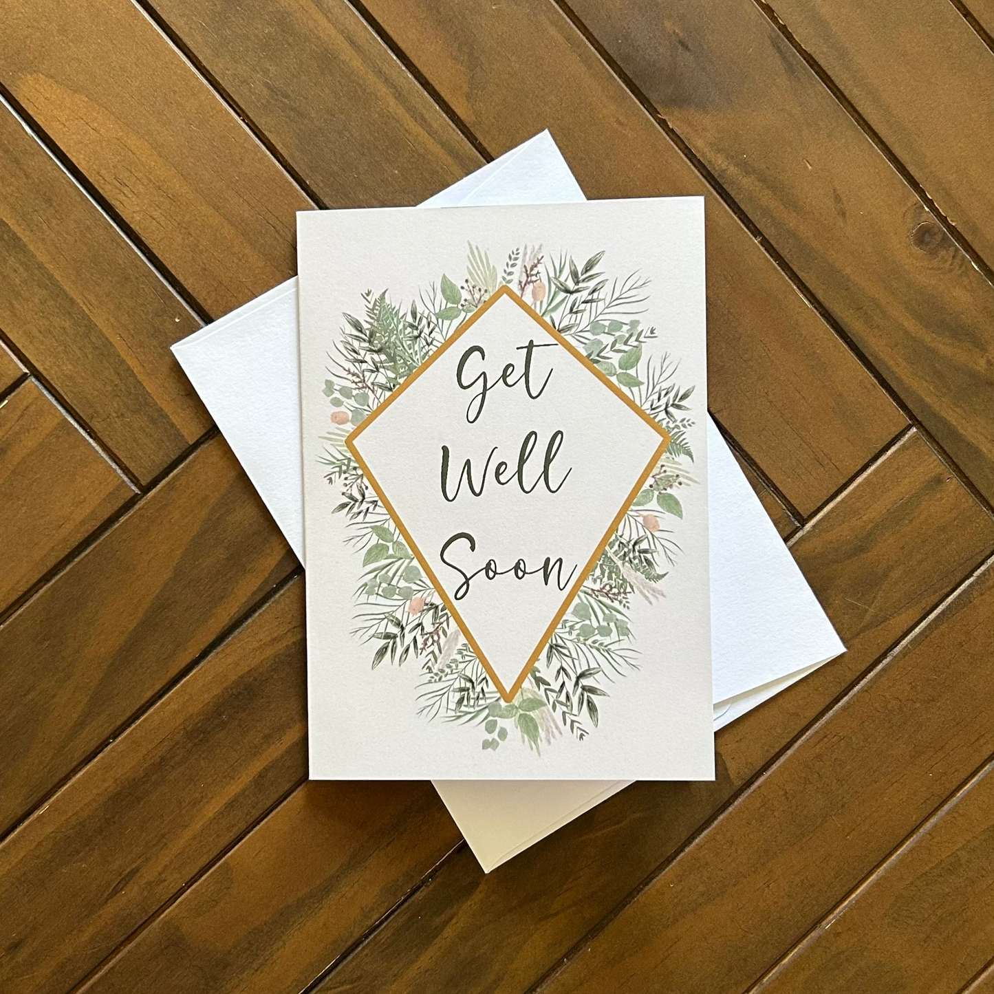 Get Well Soon card with floral design on a wooden surface