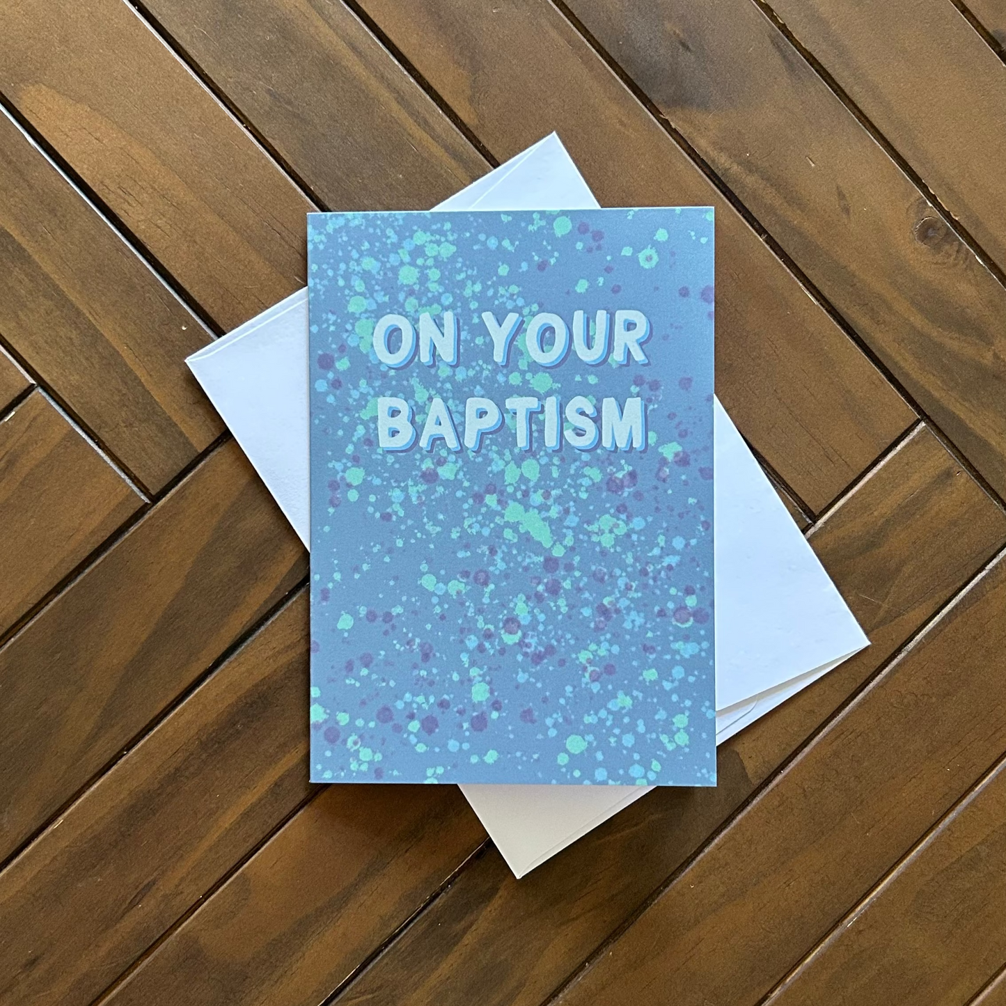 Greeting card with 'On Your Baptism' text on a wooden surface