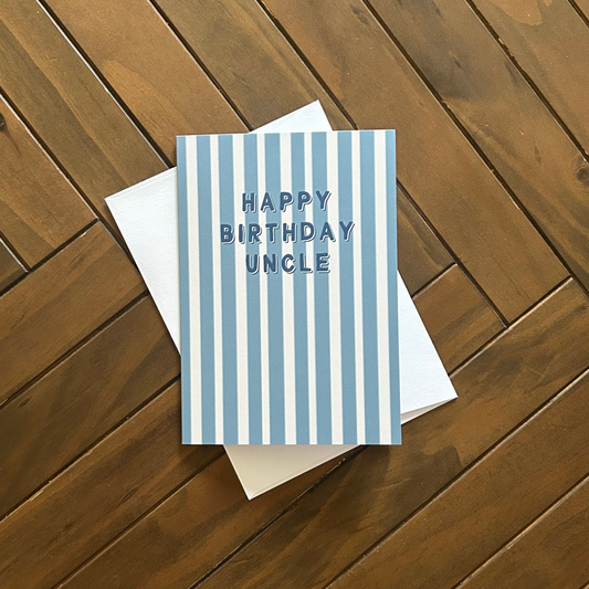 Greeting card with 'Happy Birthday Uncle' text on a wooden surface