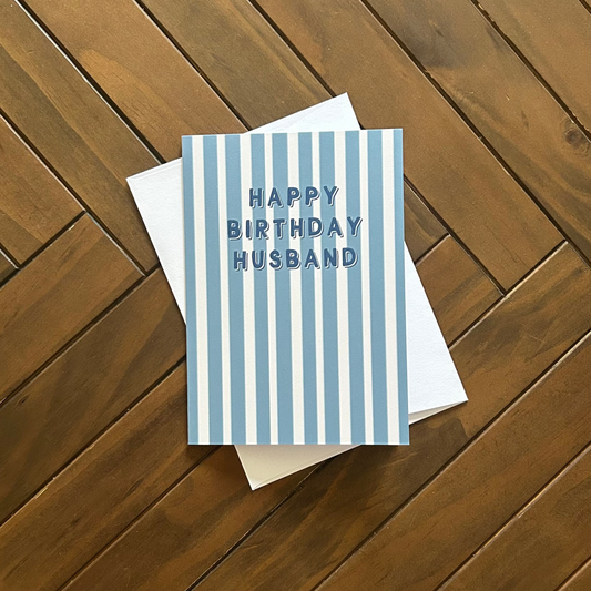 Greeting card with 'Happy Birthday Husband' text on a wooden surface