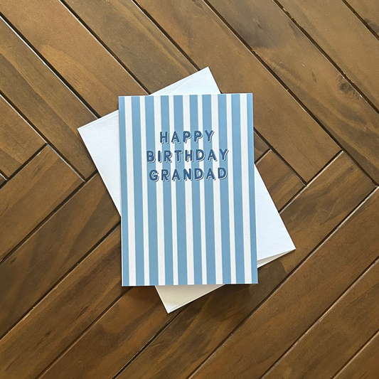 Blue striped birthday card for grandad on a wooden surface