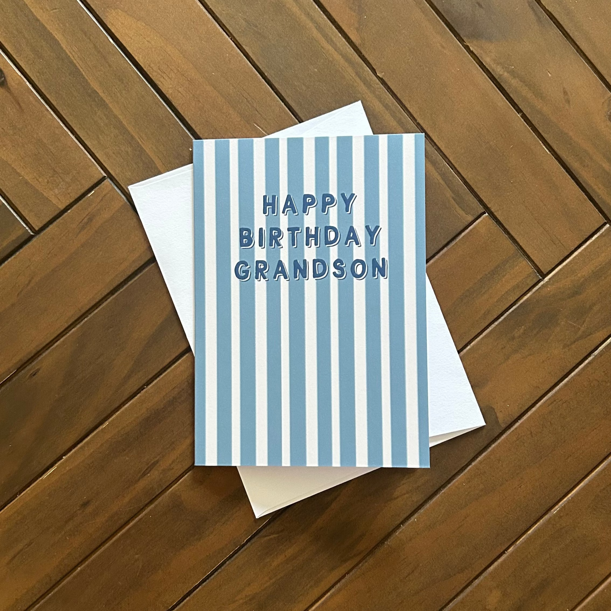 Greeting card with 'Happy Birthday Grandson' text on a wooden surface