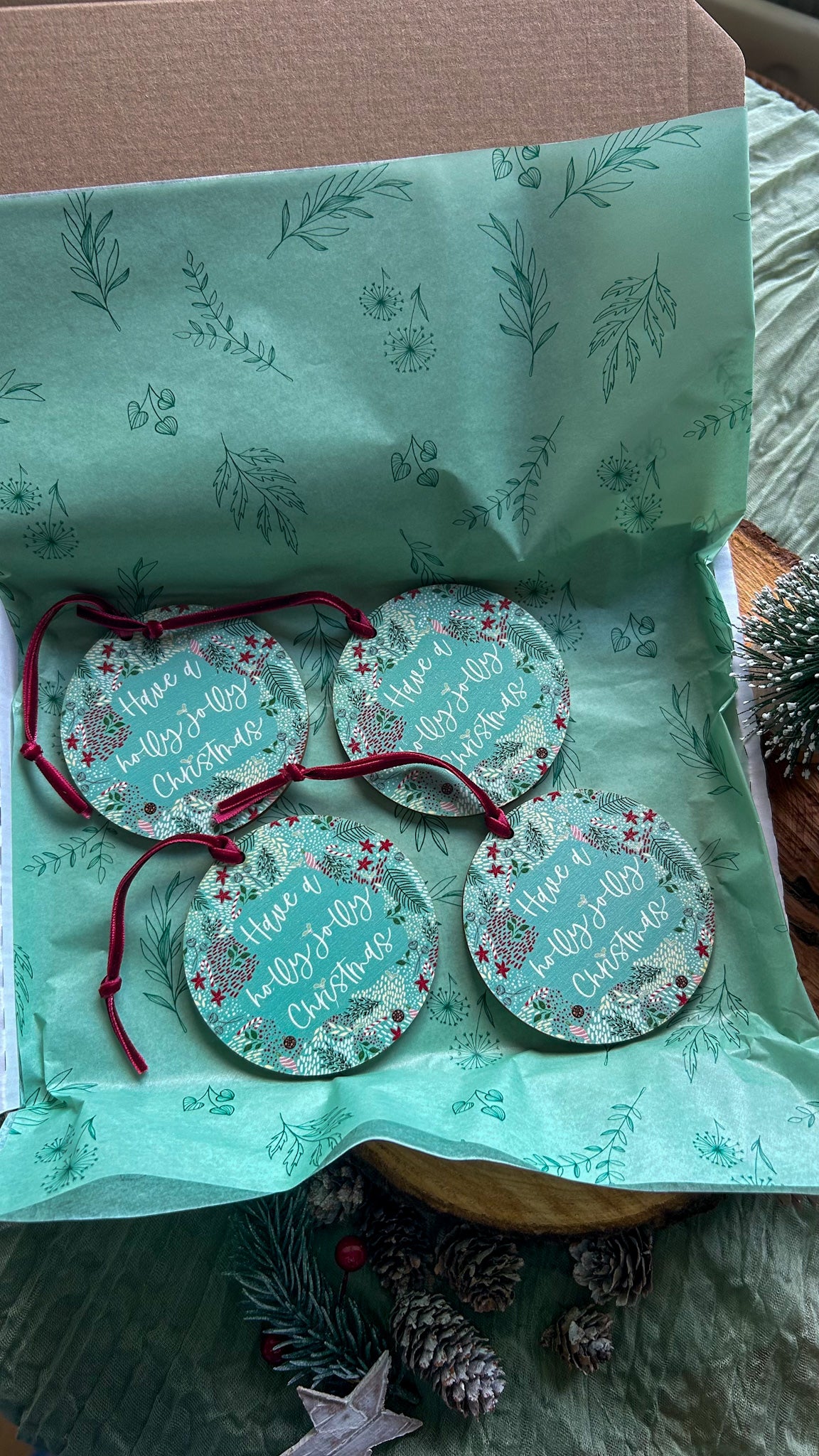 Set of 4 Wooden hanging decorations with 'Have a holly jolly Christmas' on it and a deep red velvet ribbon o